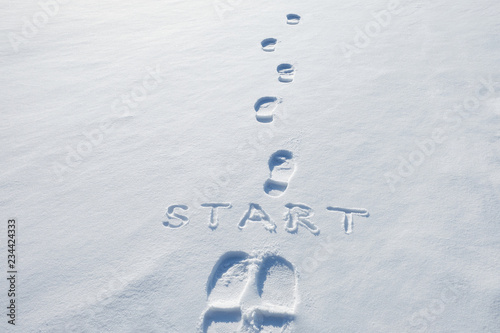 Concept picture.inscription start and footprints in the snow