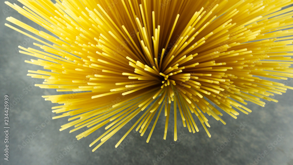 Yellow long spaghetti on a Rust stone background, Yellow italian pasta. Long spaghetti. Raw spaghetti bolognese, Food background concept, Blank for design.. Yellow long spaghetti on a Rust stone background, Yellow italian pasta. Long spaghetti. Raw spaghetti bolognese, Food background concept, Blank for design..