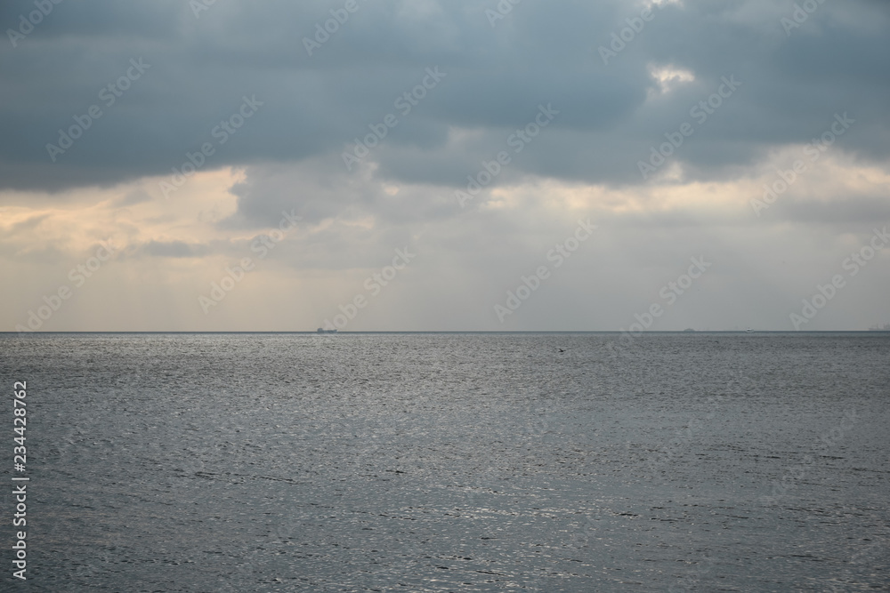 Fototapeta premium a calm sea and a skyline separating clouds