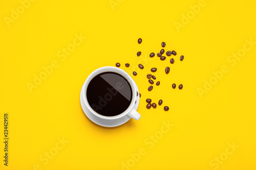 Spilled coffee beans on a bright yellow background