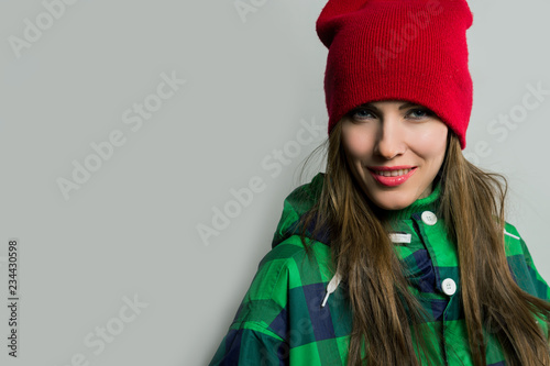 Young woman wearing bright wintersport coat and knitted hat