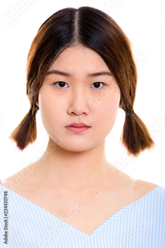 Face of young beautiful Asian woman with pigtails