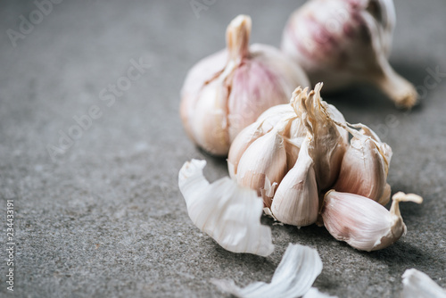 Close up view of garlic bulbs and husk on grey background