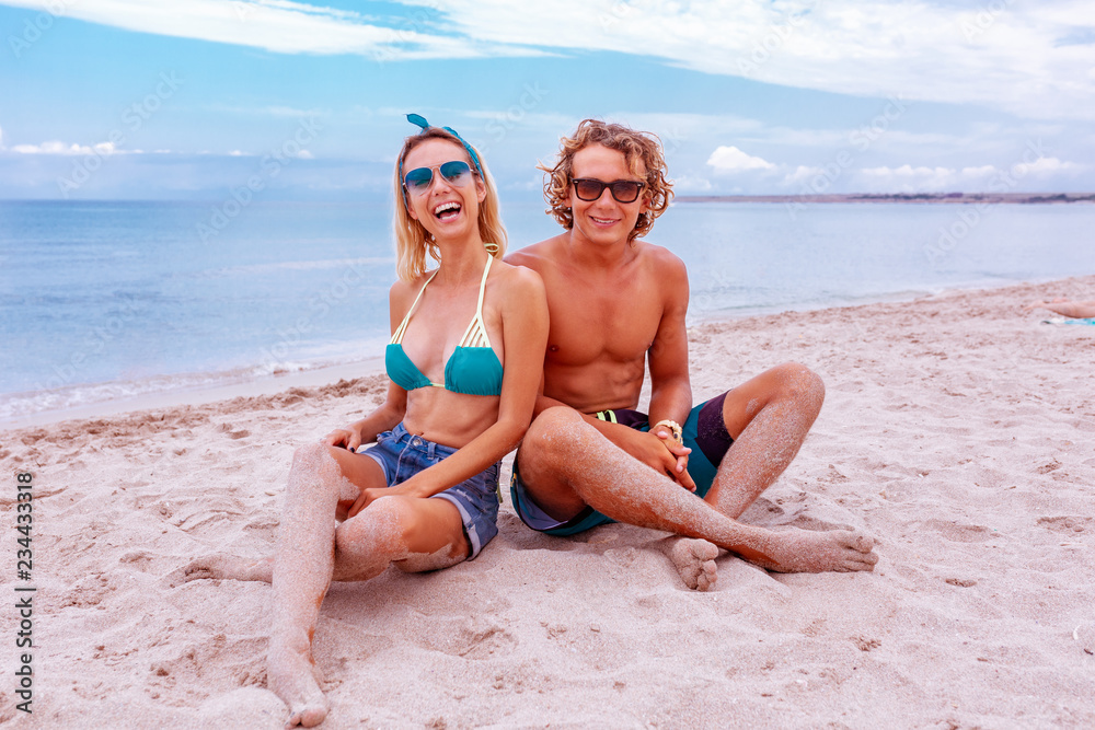Portrait of young couple in love at beach and enjoying time being together. Young couple having fun on a sandy coast. Portrait of young couple in love at beach and enjoying time being together. Young couple having fun on a sandy coast.