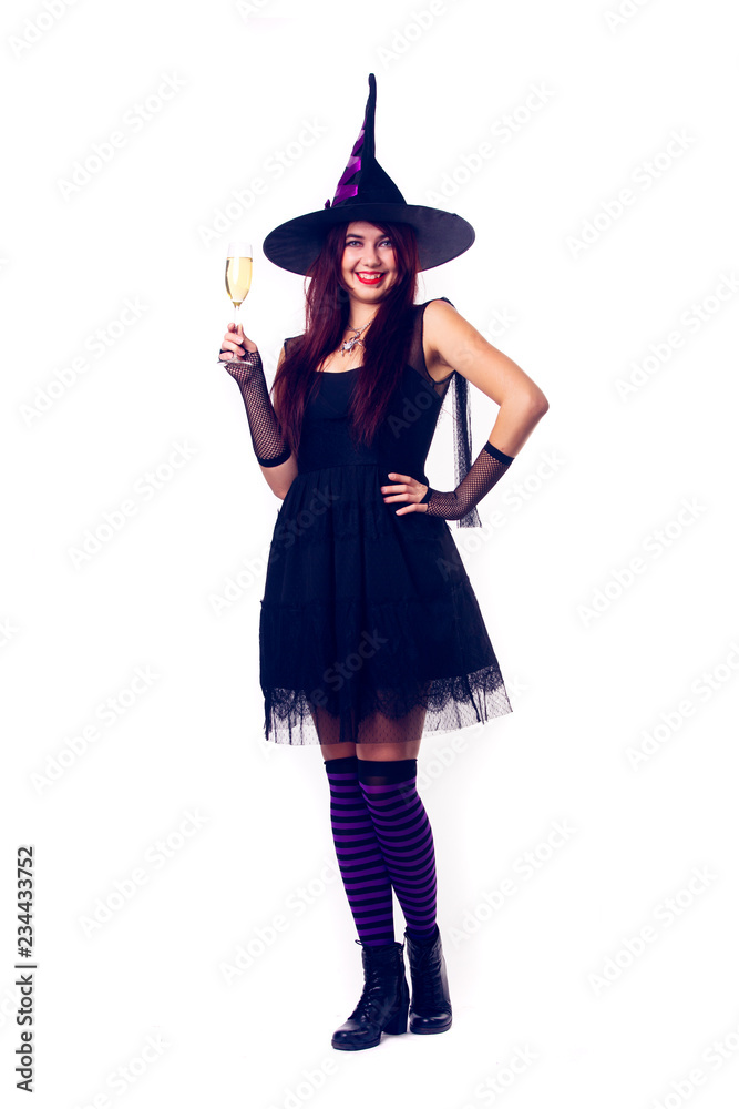 Picture of smiling witch with wine glass with wine in black dress and hat Picture of smiling witch with wine glass with wine in black dress and hat