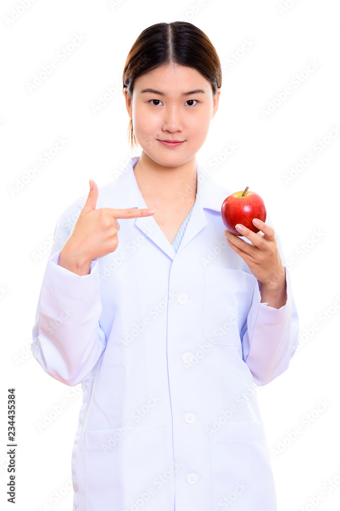Young beautiful Asian woman doctor holding and pointing at red a Young beautiful Asian woman doctor holding and pointing at red a