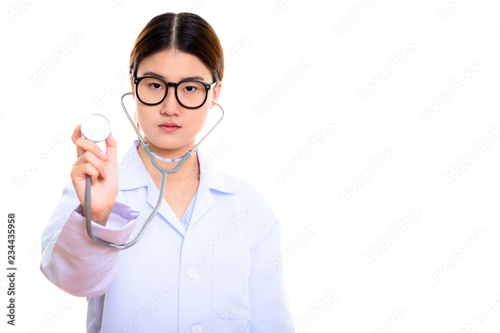 Studio shot of young beautiful Asian woman doctor using stethosc Studio shot of young beautiful Asian woman doctor using stethosc