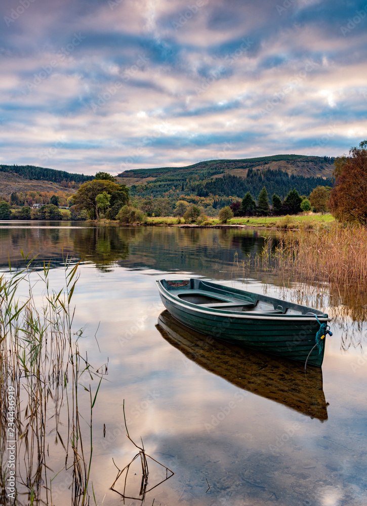 Evening light on a rowing boat on the banks of Loch Ard in the Trossachs