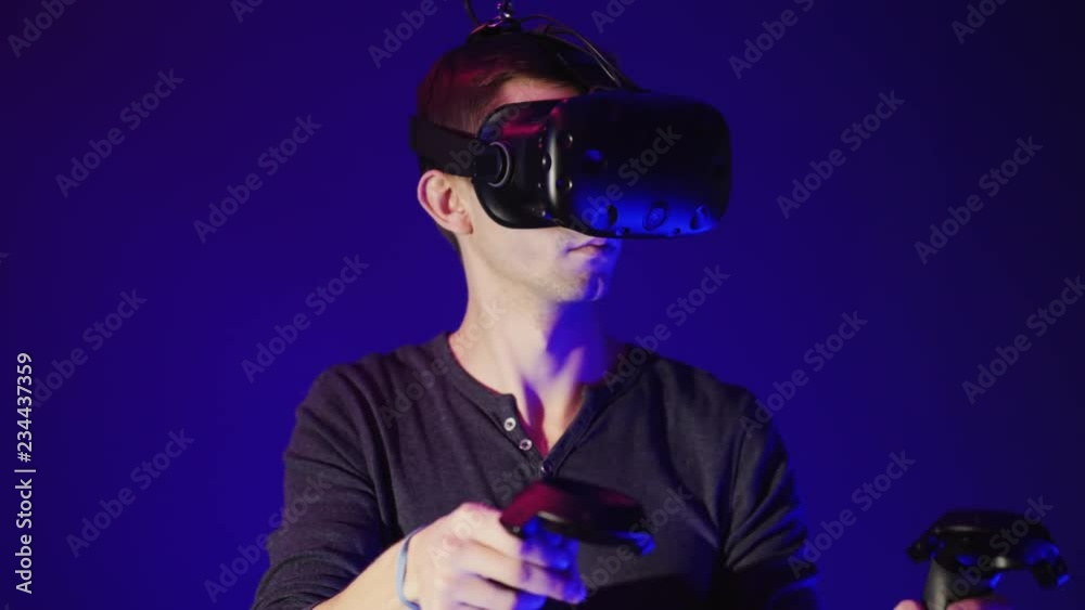 Young man using modern virtual reality headset with gamepad Young man using modern virtual reality headset with gamepad