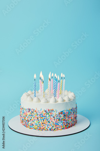 Foto Tasty birthday cake with lighting candles on blue background