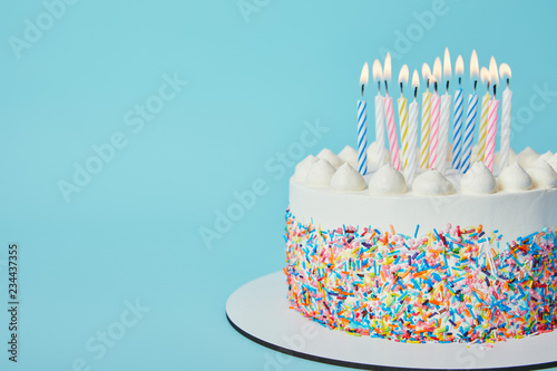 Delicious Birthday cake with lighting candles on blue background