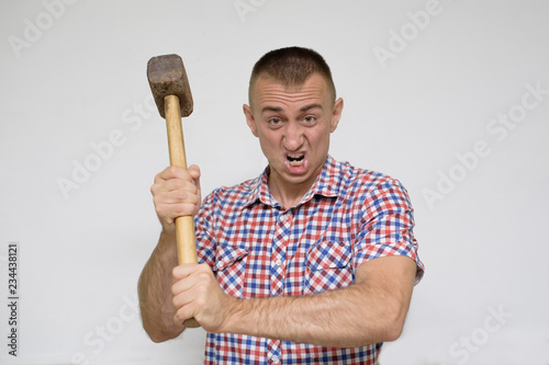 Aggressive man with a sledgehammer on a white background. Work concept
