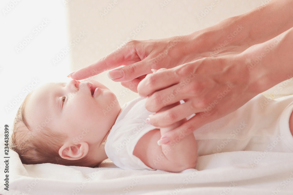 Baby and hands of mother, soft focus background Baby and hands of mother, soft focus background