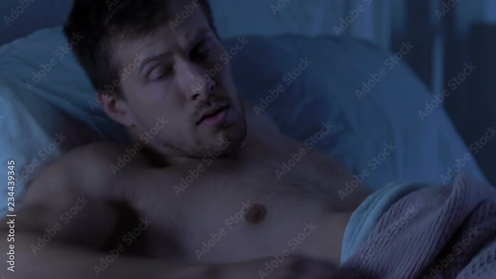Man awakened by disturbing dream, suffering from nightmares, sleep disorder Man awakened by disturbing dream, suffering from nightmares, sleep disorder