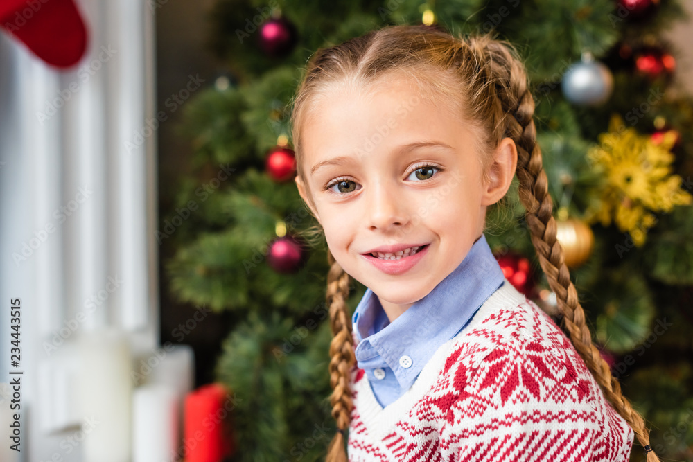 portrait of adorable happy kid smiling at camera at christmas time