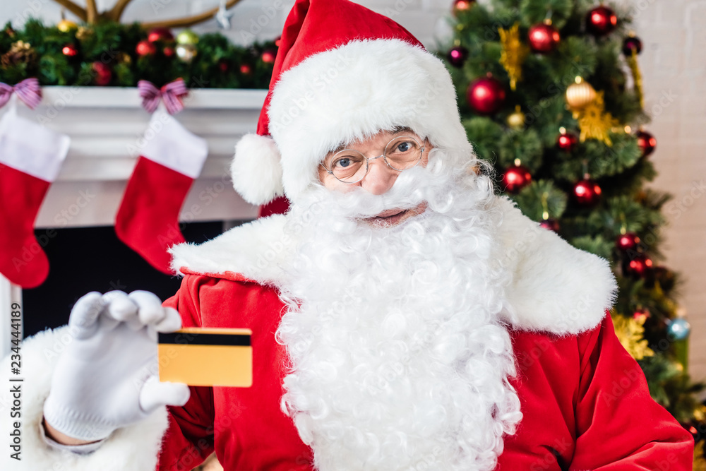 santa claus holding credit card and looking at camera santa claus holding credit card and looking at camera