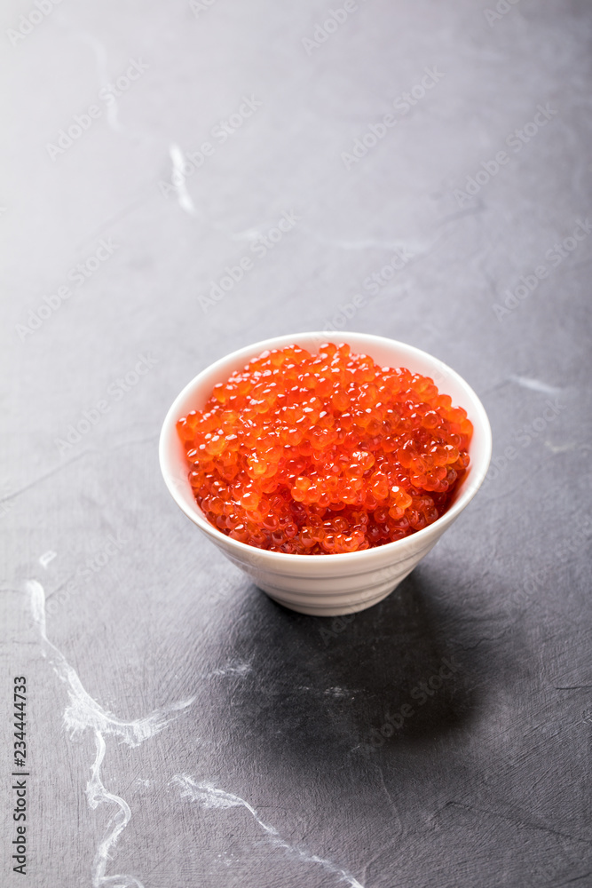 Salmon Red Caviar in a white plate on a dark background. Healthy Food Concept. Snack.Copy space for Text.Seafood. Salmon Red Caviar in a white plate on a dark background. Healthy Food Concept. Snack.Copy space for Text.Seafood.