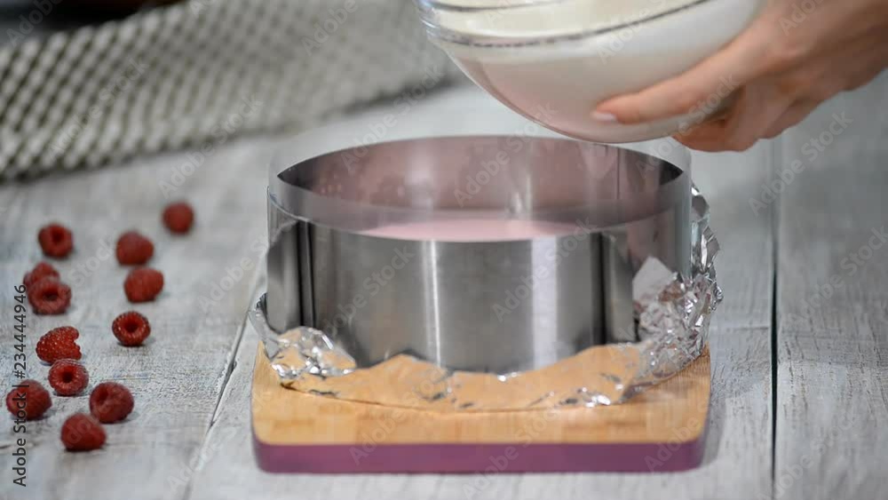 Pouring vanilla mousse. Making raspberry cream mousse cake. Raspberry cake.Cooking process. Pouring vanilla mousse. Making raspberry cream mousse cake. Raspberry cake.Cooking process.