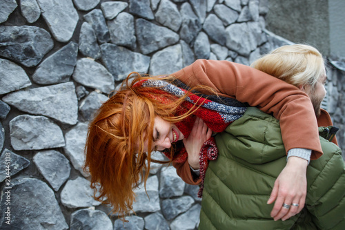 Winter holiday, dating, fashion and drive emotions concept. Happy stylish couple hot embracing in the winter street