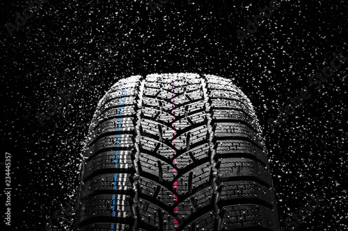 Winter Car tires with snow on black background photo