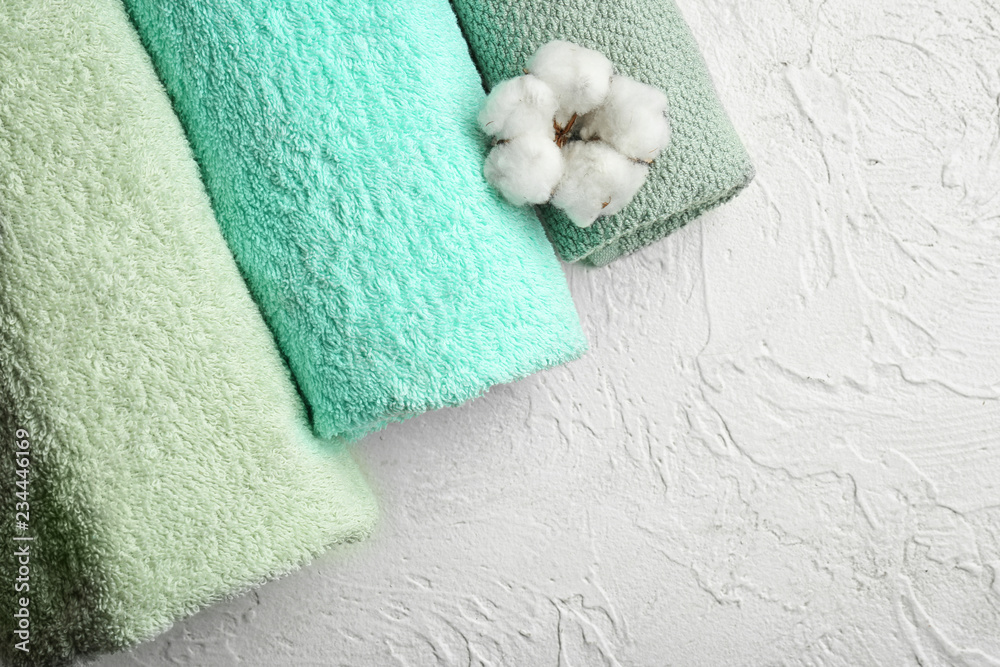 Rolled clean soft towels with cotton flower on white background