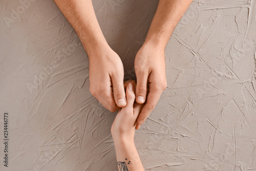 Man holding hand of woman on grey background