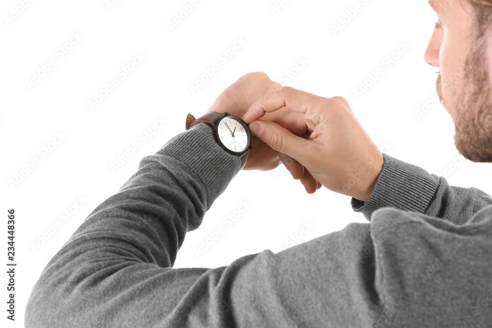 Young man looking at his watch on white background Young man looking at his watch on white background
