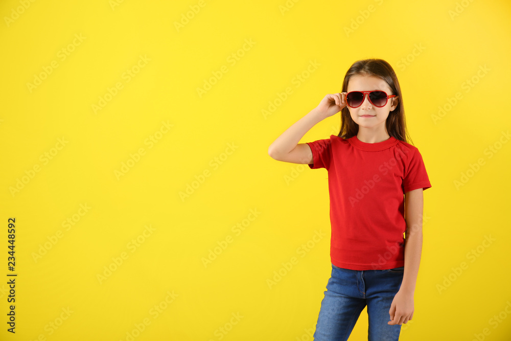 Cute girl in t-shirt on color background