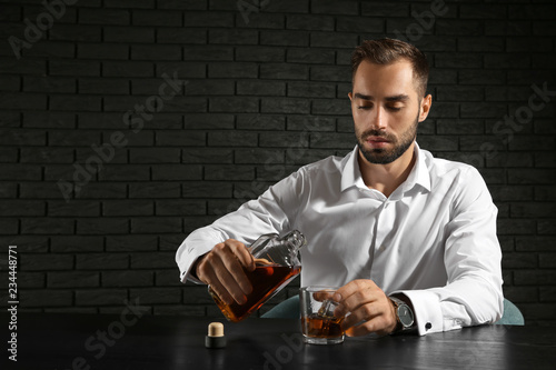 Man pouring whiskey into gl...
