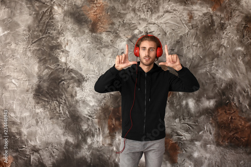 Young man listening to music on grunge background