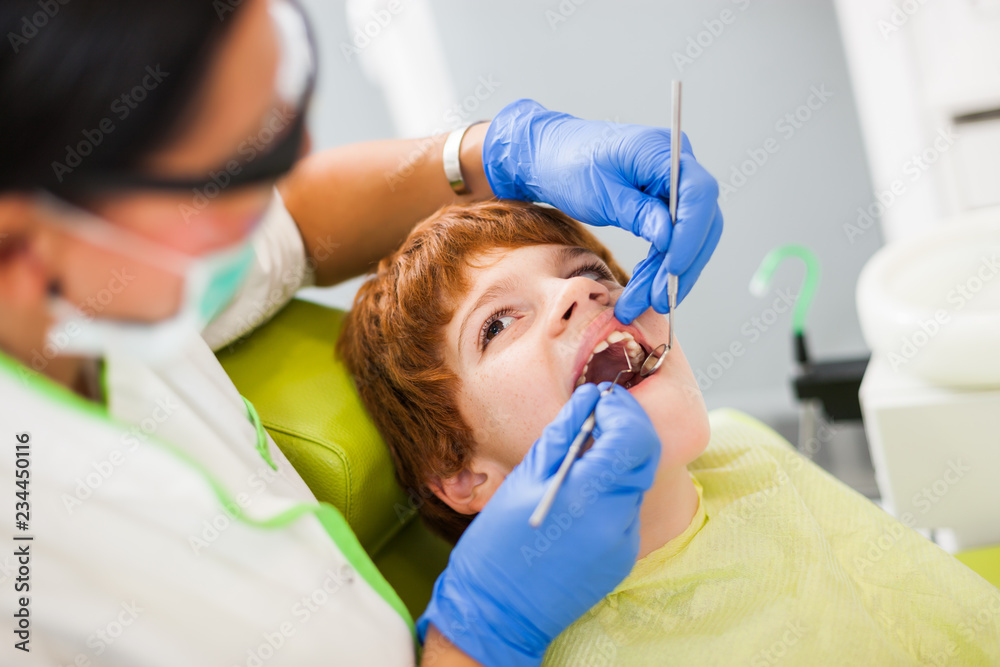 Dentist is examining teeth of a boy. Dentist is examining teeth of a boy.