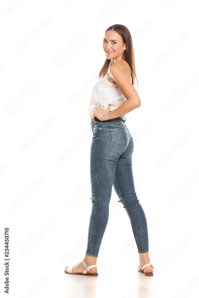 Barefoot young beautiful girl in jeans posing on white backgeound foto de  Stock | Adobe Stock