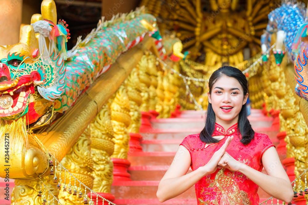Fototapeta premium Portrait chinese woman red dress traditional cheongsam in chinese temple.