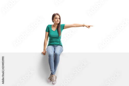 Beautiful young female sitting at a panel and pointing