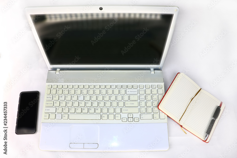 white laptop, smartphone and diary with pen on a light background white laptop, smartphone and diary with pen on a light background