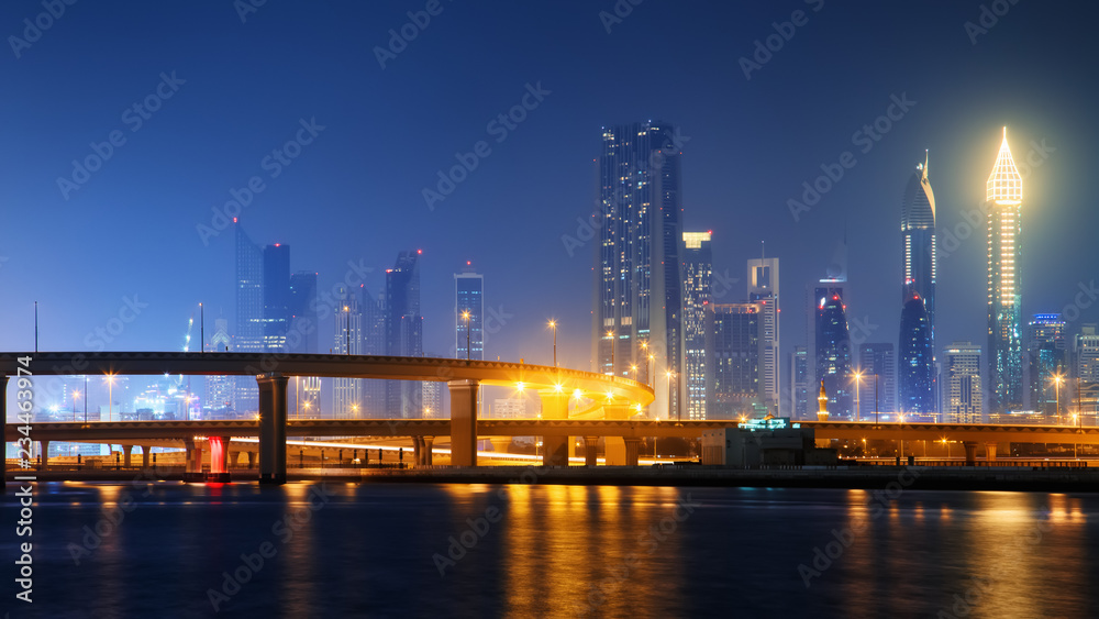 Beautiful view to Dubai downtown city center skyline reflected in water at night, United Arab Emirates