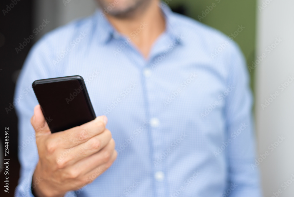 Closeup of man networking on smartphone. Person holding digital gadget. Technology and communication concept. Cropped front view. Closeup of man networking on smartphone. Person holding digital gadget. Technology and communication concept. Cropped front view.