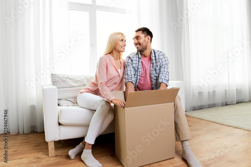 delivery, mail and people concept - happy couple with open parcel box at home © Syda Productions