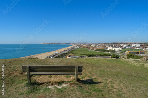 An empty park bench on Seaford Head Sussex UK, overlooking the town on a sunny day