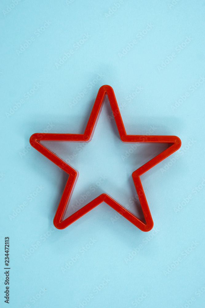 Obraz premium Cookie cutter star shape on light blue background