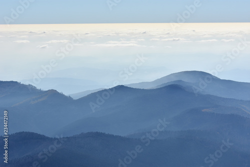 Peaceful blue nature background with foggy Bucegi mountains in Carpathians seen from Cota 2000  Sinaia resort  Romania