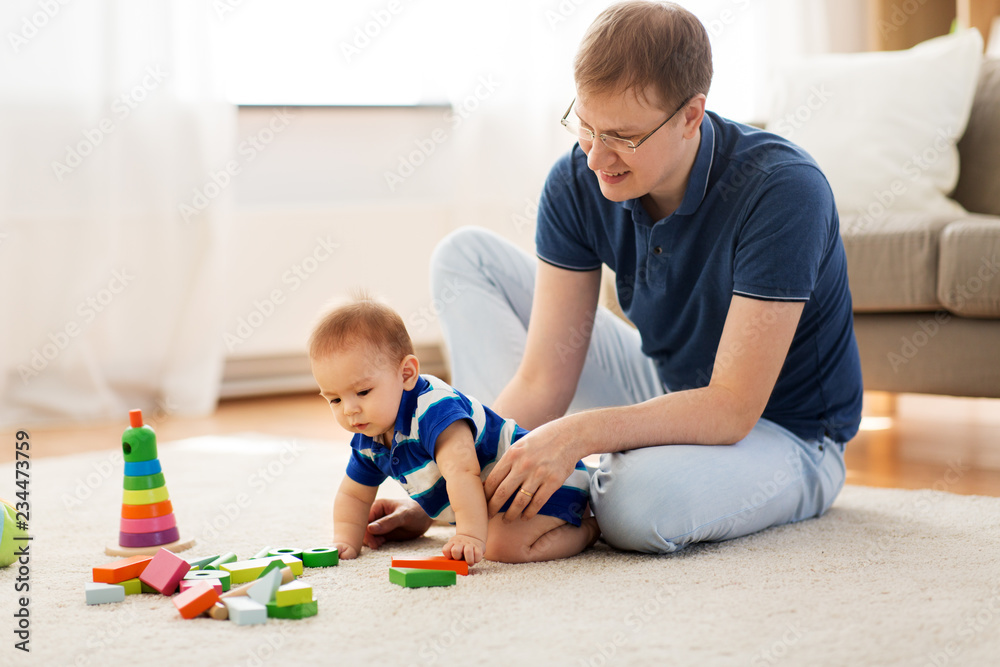 family, fatherhood and people concept - happy father with little baby son playing with toy blocks at home family, fatherhood and people concept - happy father with little baby son playing with toy blocks at home