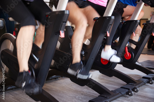 Close Up Of Feet On Exercise Bikes In Gym Spinning Class