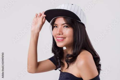 cute happy smiling woman wearing cap. portrait of positive optimistic urban woman with modern fashion  studio white isolated with friendly girl face. young adult beautiful girl asian woman model
