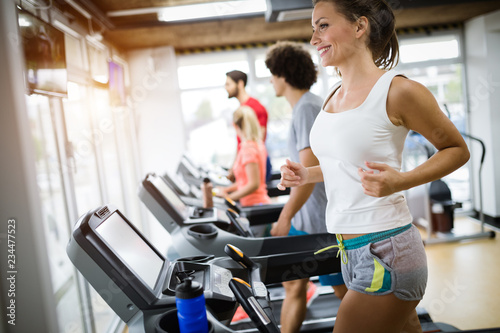 Group of friends exercising on treadmill machine © NDABCREATIVITY