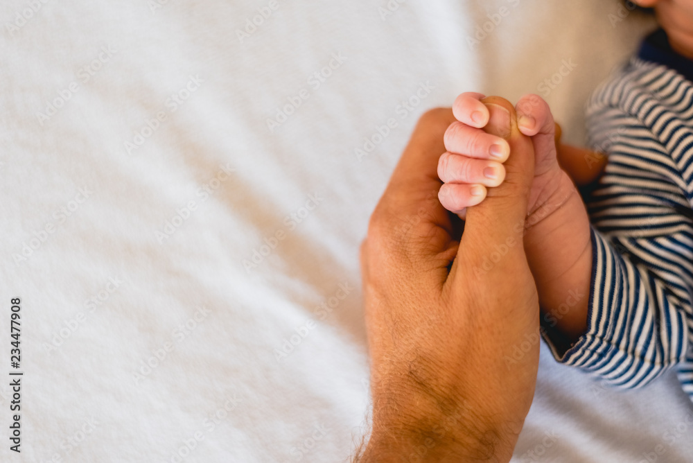 Newborn baby securely grasping his mother's hands, close-up fingers. - obrazy, fototapety, plakaty 