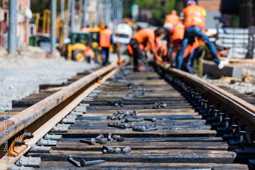 Fotografia Workers in bright uniforms lay railway or tram tracks