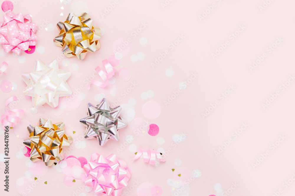 Confetti, bows and paper decorations. Valentines day or birthday party concept theme. Flat lay, top view. Confetti, bows and paper decorations. Valentines day or birthday party concept theme. Flat lay, top view.