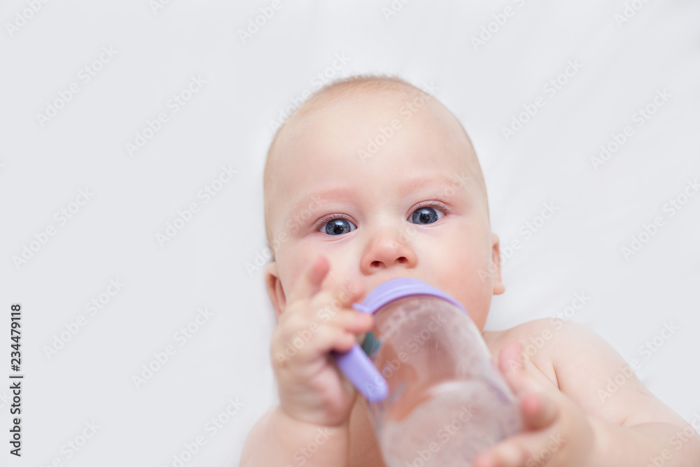 infant is drinking from a bottle and lying infant is drinking from a bottle and lying