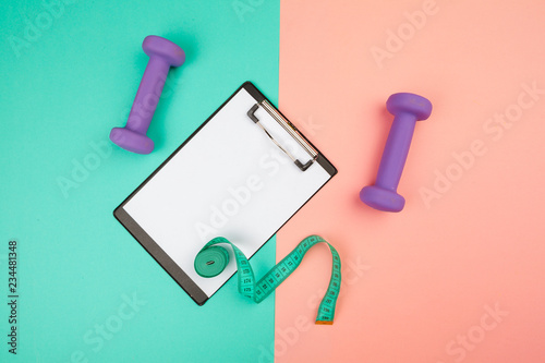 Mockup clipboard with Gym equipment dumbbell on blue and pink background